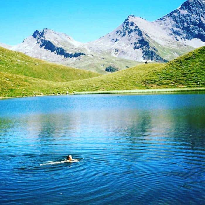 someone swimming in glacial lake French Alps