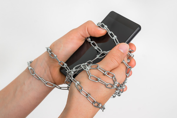 hands chained to phone digital detox
