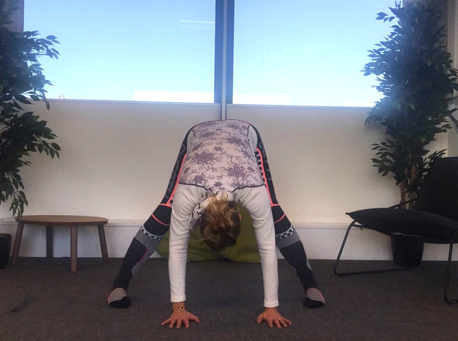 person doing wide legged forward bend yoga pose