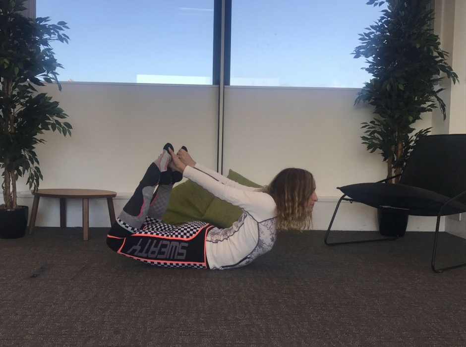 person doing bow pose on floor for yoga for skiing poses