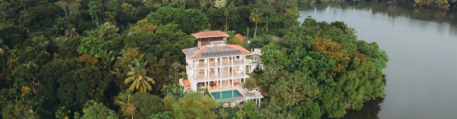 large villa surrounded by trees and a lake in sri lanka