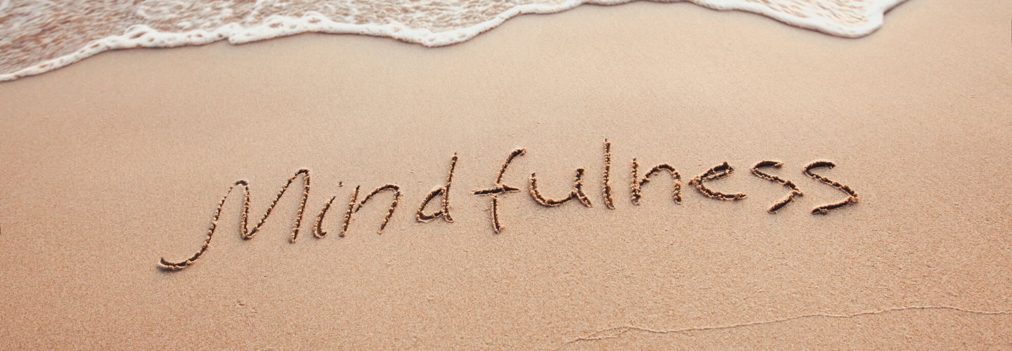 mindfulness written in sand