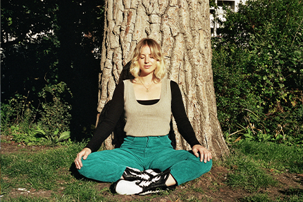 woman cross legged under tree