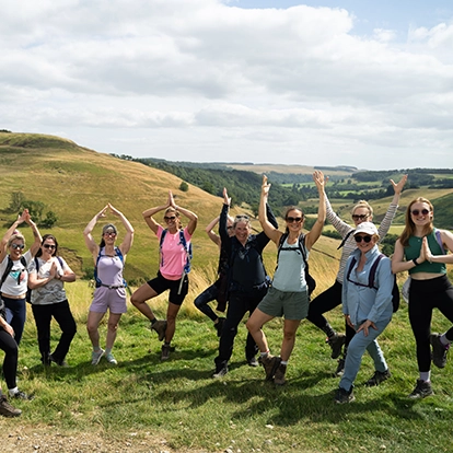 people doing a yoga pose at the top of a summit in yorkshire dales