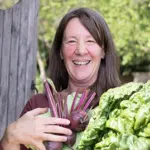 hayley north vegetarian chef smiling with fresh vegetables