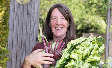 hayley north vegetarian chef smiling with fresh vegetables