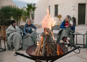 people gathered around a campfire with blankets in essaouira