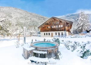 french alps chalet in the snow with hot tub